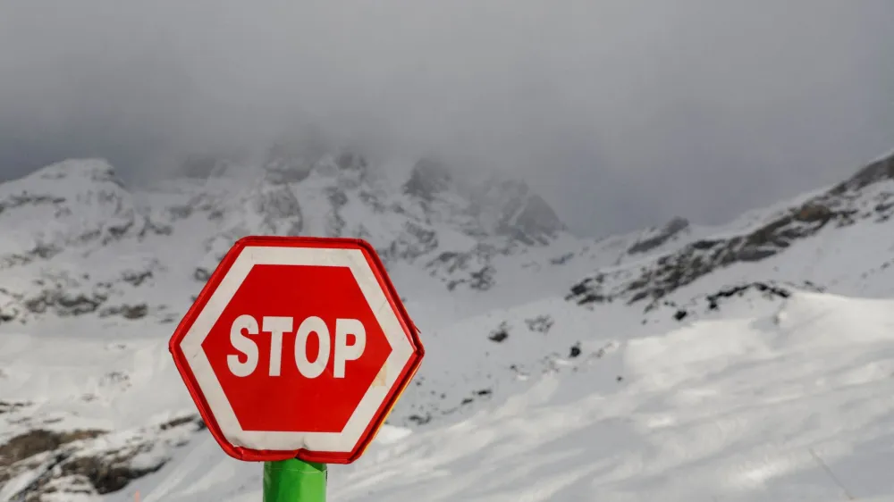 Alpine Skiing - FIS Alpine Ski World Cup - Women's Downhill - Cervinia, Italy - November 18, 2023 A stop sign is pictured infront of Matterhorn mountain as the race is cancelled REUTERS/Leonhard Foeger