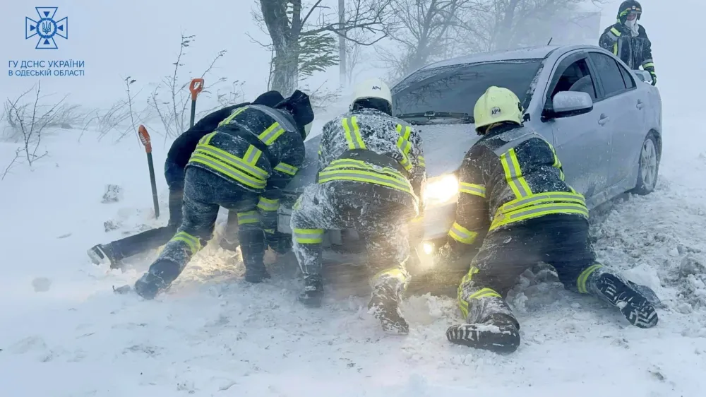 Emergency workers release a car which stuck in snow during a heavy snow storm in Odesa region, Ukraine in this handout picture released November 27, 2023. Press service of the State Emergency Service of Ukraine in Odesa region/Handout via REUTERS ATTENTION EDITORS - THIS IMAGE HAS BEEN SUPPLIED BY A THIRD PARTY. DO NOT OBSCURE LOGO.