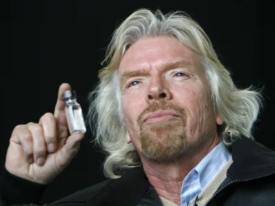 Virgin Group chairman Richard Branson holds up a bottle filled with what he says is biofuel, before the world's first commercial biofuel flight of a Virgin Atlantic Boeing 747 aircraft to Amsterdam from Heathrow Airport in London February 24, 2008. Nuts picked from Amazon rainforests helped fuel the world's first commercial airliner flight powered by renewable energy on Sunday.   REUTERS/Luke MacGregor  (BRITAIN)