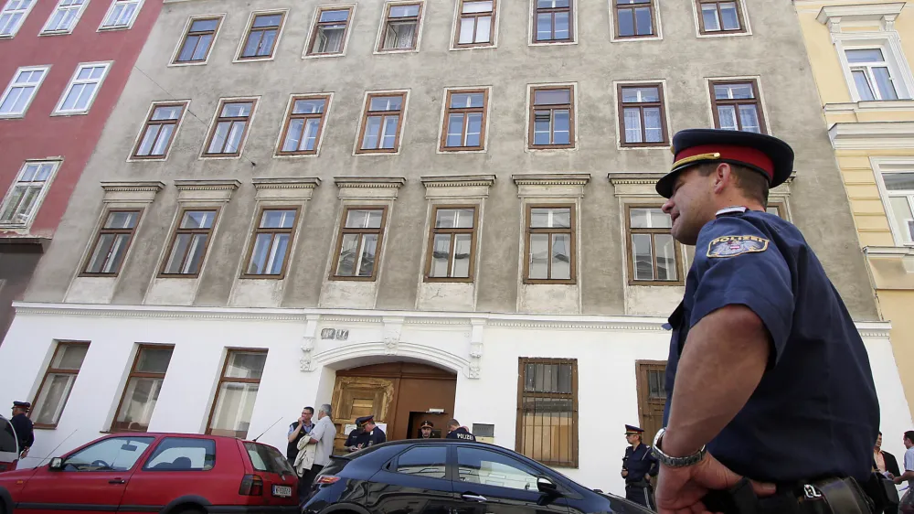 A policeman stands in front of a house in Vienna's Rudolfsheim district, housing an Indian temple, following a shooting Sunday May 24, 2009, inside the building. Police in Austria say up to 30 people have been wounded, nine severely, in a shooting at the Indian temple. Police spokesman Michael Takacs told Austria Press Agency five men entered a place of worship for an Indian religious community early afternoon Sunday and started firing at those present. Police arrested all five suspects, Takacs said. (AP Photo/Ronald Zak)