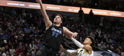 Dallas Mavericks guard Luka Doncic (77) scores past Utah Jazz guard Keyonte George (3) during the second half of an NBA basketball game in Dallas, Wednesday, Dec. 6, 2023. (AP Photo/LM Otero)