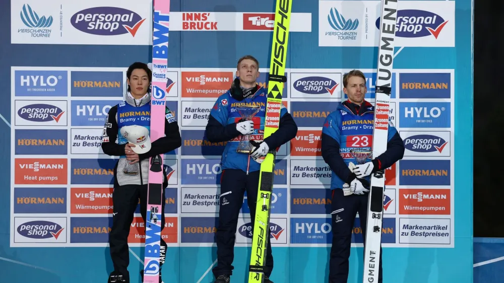 Ski Jumping - 4 Hills Tournament - Innsbruck, Austria - January 3, 2024 Austria's Jan Hoerl celebrates with the trophy on the podium after winning along with second placed Japan's Ryoyu Kobayashi and third placed Austria's Michael Hayboeck REUTERS/Kai Pfaffenbach
