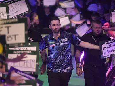 Luke Humphries of England arrives for the quarterfinal match against Dave Chisnall of England at the World Darts Championship, in London, Monday, Jan. 1, 2024. (AP Photo/Kin Cheung)