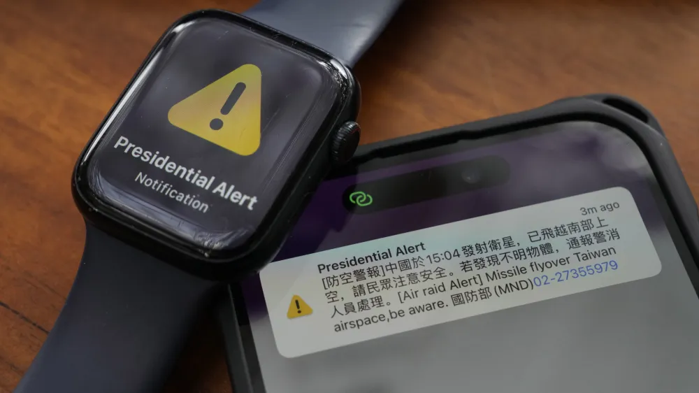 A phone and watch that received an air raid alert is placed together for a photo in New Taipei City, Taiwan Tuesday, Jan. 9, 2024. Taiwan's defense ministry has issued an alert saying China has launched a satellite and urging caution. The Chinese reads ""Air Raid Alert. China at 15:04 launched a satellite, already flown past the southern air space, Citizens to be aware of safety. If any unidentified object is found, alert police and fire fighters to handle. National Defense Ministry." (AP Photo/Ng Han Guan)