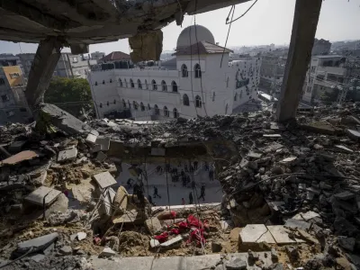 Palestinians look at a damaged residential building after an Israeli strike in Rafah, southern Gaza Strip, Wednesday, Jan. 10, 2024. (AP Photo/Fatima Shbair)