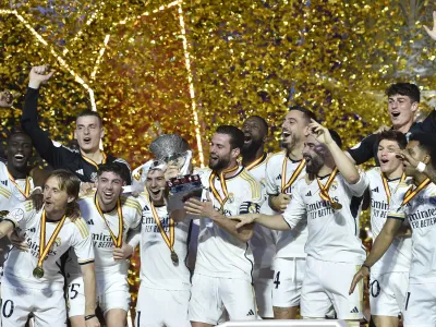 Real Madrid players celebrate with the trophy of the Spanish Super Cup after the final soccer match between Real Madrid and Barcelona at Al-Awwal Park Stadium in Riyadh, Saudi Arabia, Sunday, Jan. 14, 2024. (AP Photo)