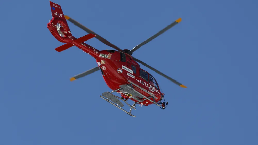 A helicopter flies evacuating United States' Mikaela Shiffrin after she crashed during an alpine ski, women's World Cup downhill race, in Cortina d'Ampezzo, Italy, Friday, Jan. 26, 2024. Shiffrin crashed into the safety nets after losing control landing a jump during a World Cup women's downhill on Friday. (AP Photo/Alessandro Trovati)