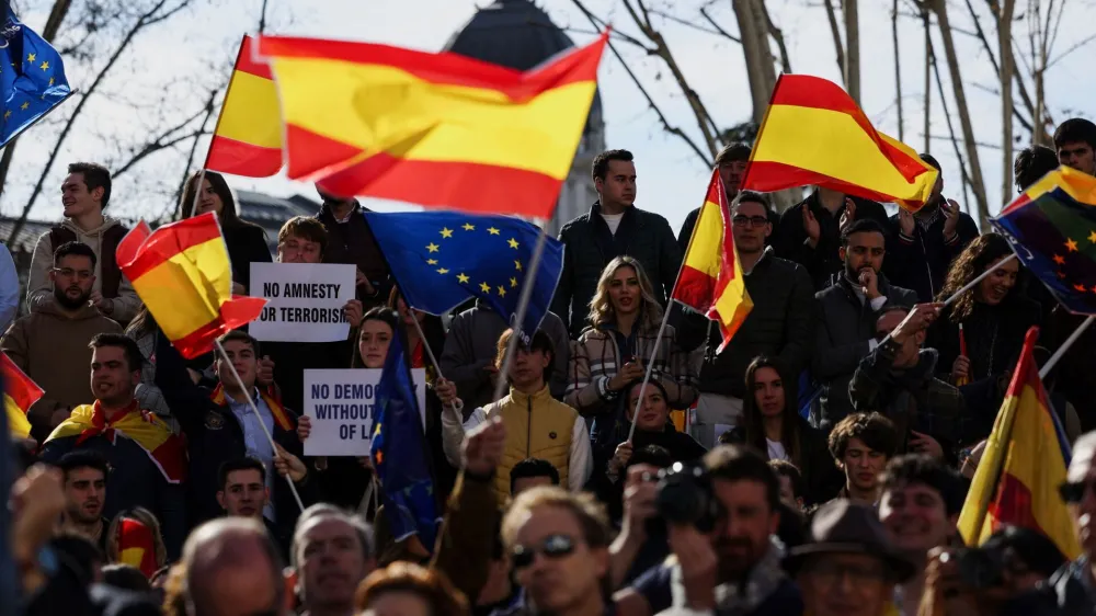 Demonstrators wave Spanish and EU flags during a protest against the Socialist government of Pedro Sanchez and its agreements with Catalan separatist parties over an amnesty law, in Plaza Espana, Madrid, Spain, January 28, 2024. REUTERS/Isabel Infantes