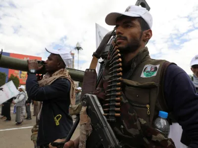 A Houthi follower holds a machine gun with ammunition belt during a parade in a show of force amid a standoff in the Red Sea and U.S.-led airstrikes on Houthi targets, in Sanaa, Yemen, February 8, 2024. REUTERS/Khaled Abdullah