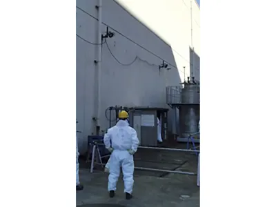 In this photo provided by Tokyo Electric Power Company Holdings, Inc. (TEPCO), a staff member examines an air vent through which a plant worker found the leak Wednesday morning, at the crippled Fukushima Daiichi nuclear power plant in Okuma town, northeastern Japan, Wednesday, Feb. 7, 2024. Highly radioactive water leaked from a treatment machine at the tsunami-hit Fukushima nuclear power plant, but no one was injured and radiation monitoring shows no impact to the outside environment, the utility operator said Thursday. (TEPCO via AP)