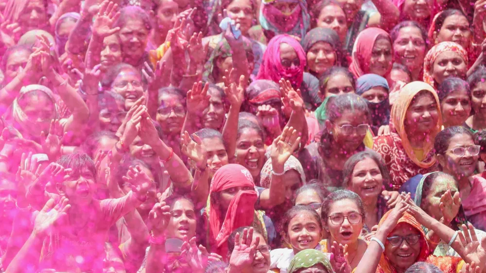 Hindu devotees pray as they are sprayed with coloured water at a temple's premises, during Holi celebrations in Ahmedabad, India March 25, 2024. REUTERS/Amit Dave