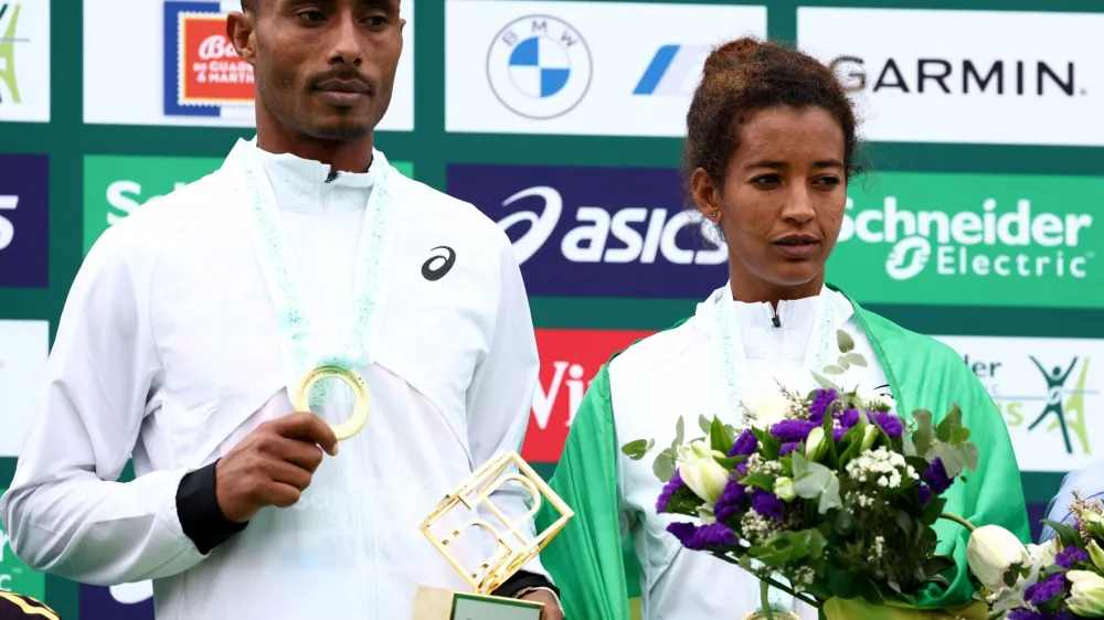 Athletics - Paris Marathon - Paris, France - April 7, 2024 Ethiopia's Mulugeta Asefa Uma and Mestawut Fikir pose atop the podium after winning the men's and women's elite races respectively REUTERS/Stephanie Lecocq