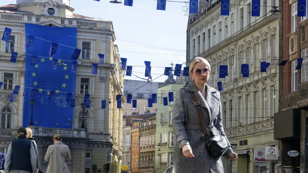 A woman walks under European Union flags placed in one of the main streets in Sarajevo, Bosnia, Thursday, March 21, 2024. European Union leaders meeting in Brussels are expected to give a greenlight to Bosnia and Herzegovina to open membership talks once certain conditions are met. (AP Photo/Eldar Emric)