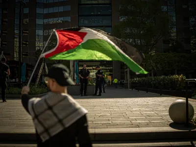 15 April 2024, US, Arlington: A protester holds a flag during a pro-Palestine protest outside Boeing HQ in Arlington against the corporation's supply of military equipment to Israel amidst its war on Gaza. Photo: Natascha Tahabsem/ZUMA Press Wire/dpa