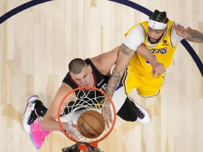 Denver Nuggets center Nikola Jokic (15) and Los Angeles Lakers forward Anthony Davis (3) tangle under the basket during the second half in Game 2 of an NBA basketball first-round playoff series, Monday, April 22, 2024, in Denver. (AP Photo/Jack Dempsey)