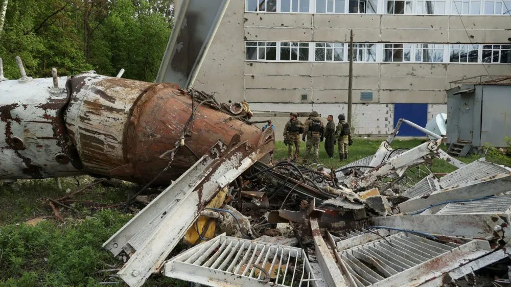 Police officers stand next to a part of a television tower partially destroyed by a Russian missile strike, amid Russia's attack on Ukraine, in Kharkiv, Ukraine April 22, 2024. REUTERS/Sofiia Gatilova