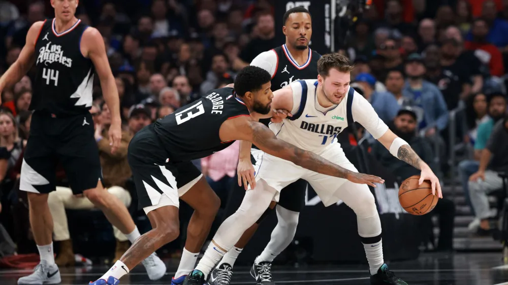 Apr 23, 2024; Los Angeles, California, USA; Dallas Mavericks guard Luka Doncic (77) is defended by Los Angeles Clippers forward Paul George (13) during the first quarter of game two of the first round for the 2024 NBA playoffs at Crypto.com Arena. Mandatory Credit: Kiyoshi Mio-USA TODAY Sports