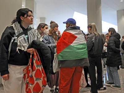 Emerson students stand outside court before being arraigned on Thursday, April 25, 2024 in Boston.  Boston police arrested more than 100 people near Emerson College overnight as officers cleared a tent encampment. (David L Ryan/The Boston Globe via AP)