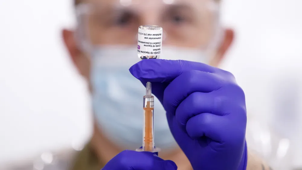 ﻿08 February 2021, England, Leeds: Sgt Phil Morris, Regimental Aid Post 4th Battalion Royal Regiment of Scotland, prepares a dose of the Oxford/AstraZeneca coronavirus vaccine ahead of being administered to patients at the Elland Road vaccination centre. Photo: Danny Lawson/PA Wire/dpa