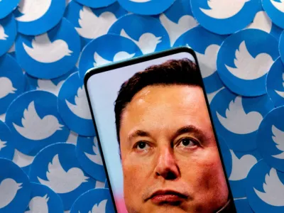 FILE PHOTO: An image of Elon Musk is seen on a smartphone placed on printed Twitter logos in this picture illustration taken April 28, 2022. REUTERS/Dado Ruvic/Illustration/File Photo