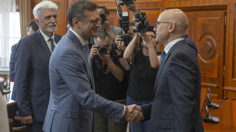 Serbian Prime Minsiter Milos Vucevic, front right, shakes hands with Ukraine's Foreign Minister Dmytro Kuleba, front left, in Belgrade, Serbia, Monday, May 13, 2024. Kuleba, who has arrived on a surprise visit to Russia-friendly Serbia, held talks on Monday in Belgrade in a sign of warming relations between the two states. (AP Photo/Marko Drobnjakovic)
