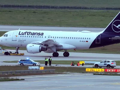 18 May 2024, Bavaria, Munich: Two activists have glued themselves to an access road for runways at Franz-Josef-Strauß Airport. The activists had reached the inner area of the airport grounds. According to their own statements, members of the 'Last Generation' activism group had planned to enter the airport grounds in order to block at least one of the two runways. Photo: Karl-Josef Hildenbrand/dpa