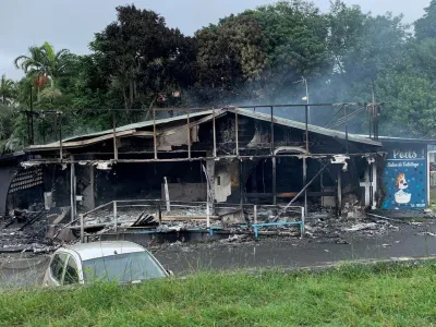 FILE PHOTO: A damaged building is seen as rioters protest against plans to allow more people to take part in local elections in the French-ruled territory, which indigenous Kanak protesters reject, in Noumea, New Caledonia, May 15, 2024, in this picture obtained from social media. Lilou Garrido Navarro Kherachi/via REUTERS/File Photo