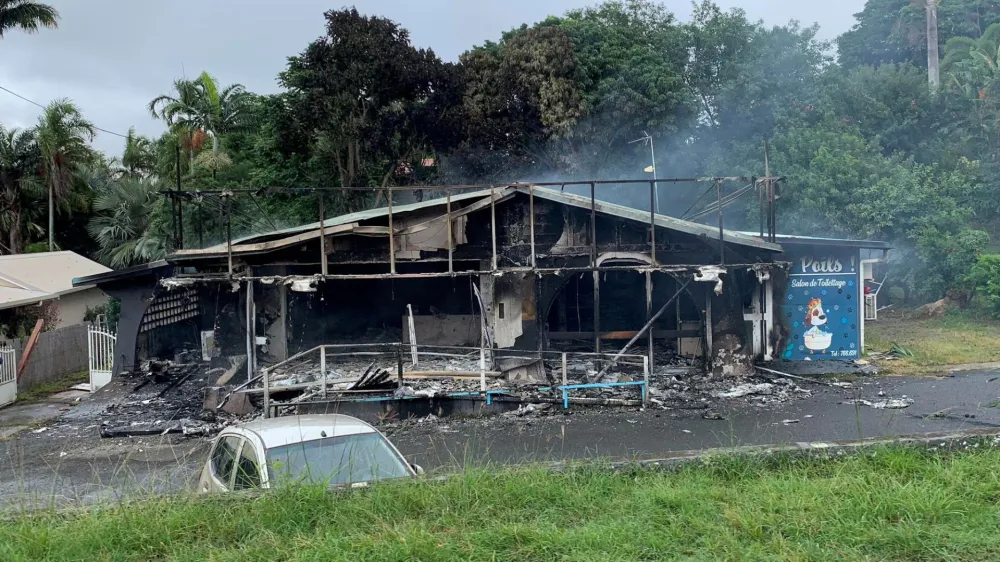FILE PHOTO: A damaged building is seen as rioters protest against plans to allow more people to take part in local elections in the French-ruled territory, which indigenous Kanak protesters reject, in Noumea, New Caledonia, May 15, 2024, in this picture obtained from social media. Lilou Garrido Navarro Kherachi/via REUTERS/File Photo