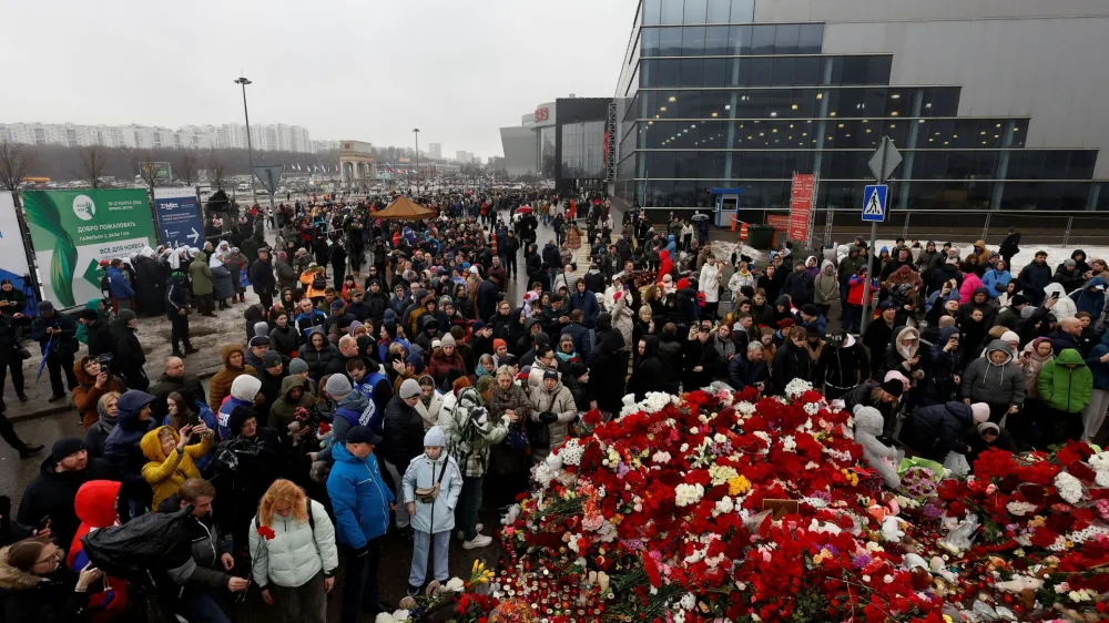 People gather at a makeshift memorial to the victims of a shooting attack set up outside the Crocus City Hall concert venue in the Moscow Region, Russia, March 24, 2024. REUTERS/Maxim Shemetov