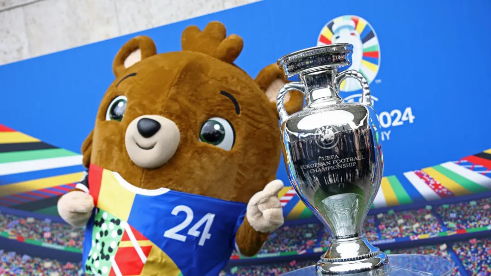 Soccer Football - Euro 2024 - Trophy Display at Olympiastadion - Olympiastadion, Berlin, Germany - April 24, 2024 Euro 2024 mascot Albart poses with the European Championship trophy REUTERS/Liesa Johannssen