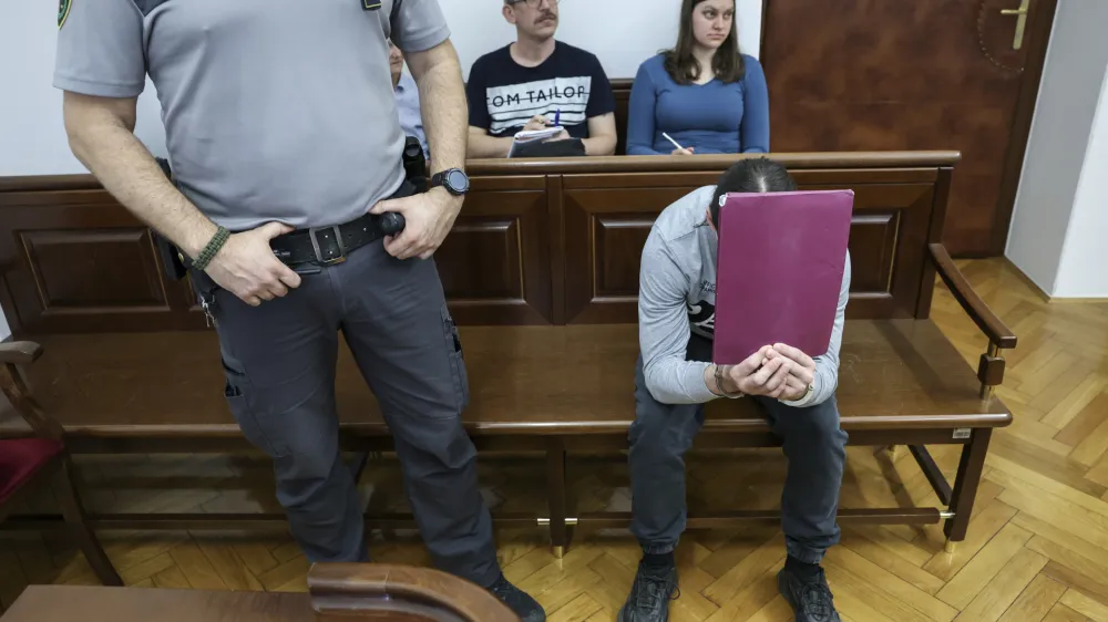 Luka Bohnec, ki se na fotografiji skriva za mapo, ne priznava krivde za poskus uboja oktobra lani. Se je pa za svoje dejanje opravičil in poudaril, da nikomur ni želel storiti nič žalega. 