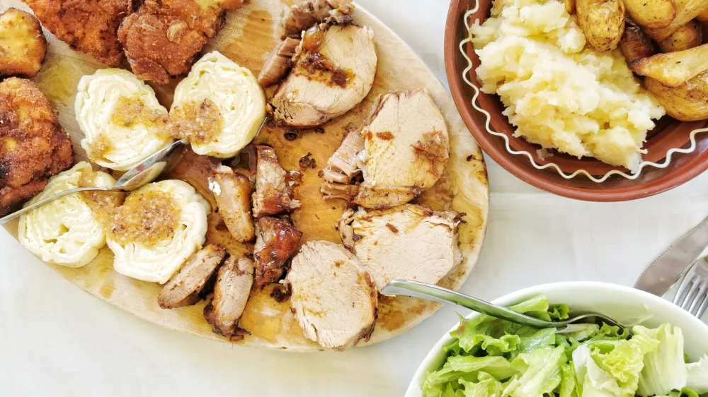 Pohana piška, svinjski kare in priloge / Foto: Miha First