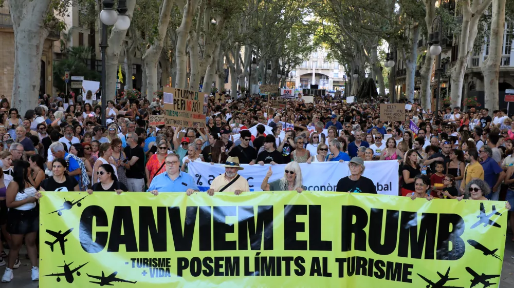 21 July 2024, Spain, Palma de Mallorca: People take part in a demonstration called by the organization "Less Tourism, More Life" against mass tourism on Mallorca. Photo: Clara Margais/dpa
