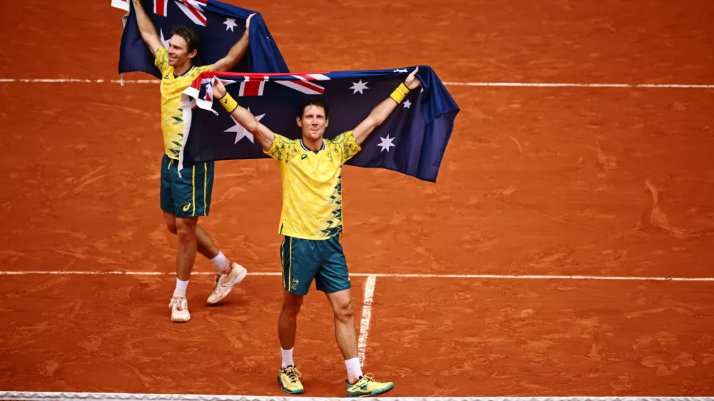 03 August 2024, France, Paris: Australia's tennis players John Peers and Matthew Ebden holding Australian flags, celebrate beating USA's Austin Krajicek and Rajeev Ram during their men's doubles final tennis match on Court Philippe-Chatrier at the Roland-Garros Stadium during the Paris 2024 Olympic Games. Photo: Dan Himbrechts/AAP/dpa