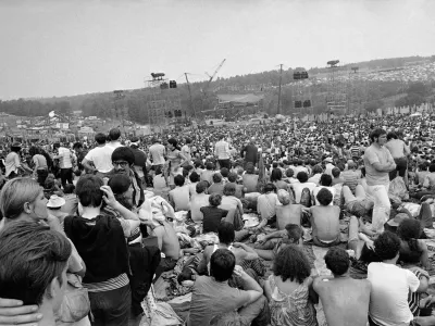 FILE - This Aug. 14, 1969 file photo shows a portion of the 400,000 concert goers who attended the Woodstock Music and Arts Festival held on a 600-acre pasture near Bethel, N.Y. It was great spot for peaceful vibes, but miserable for handling the hordes coming in by car. Fifty years later, memories of the anarchic weekend of Aug. 15-18, 1969, remains sharp among people who were in the crowd and on the stage for the historic festival. (AP Photo/File)