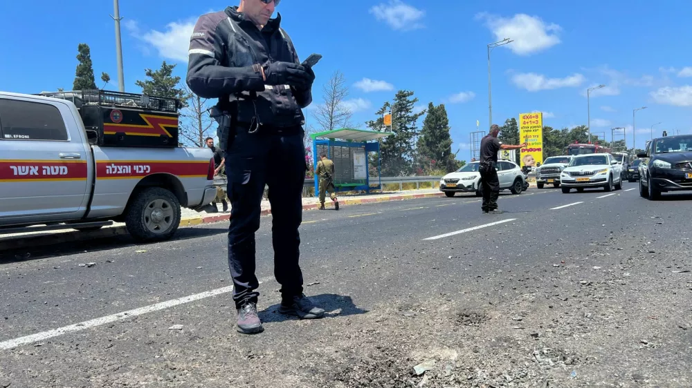 An Israeli policeman inspects the impact site of a projectile, after Lebanon's armed group Hezbollah said it launched a swarm of attack drones against military targets in northern Israel, in Nahariya, northern Israel, August 6, 2024. REUTERS/Avi Ohayon