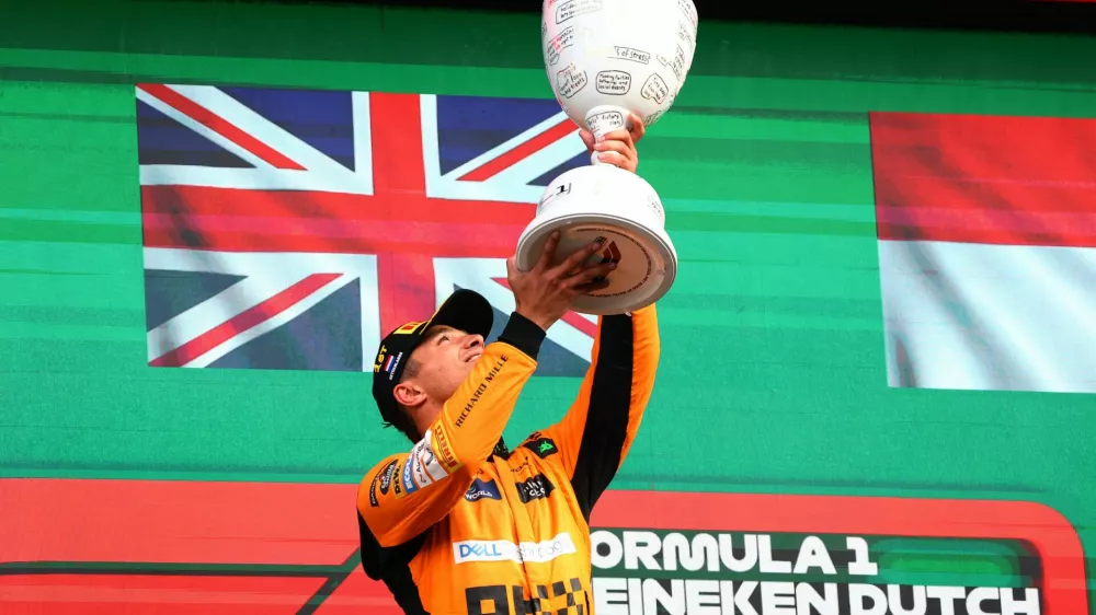 Formula One F1 - Dutch Grand Prix - Circuit Zandvoort, Zandvoort, Netherlands - August 25, 2024 McLaren's Lando Norris celebrates with a trophy on the podium after winning the Dutch Grand Prix REUTERS/Lisi Niesner