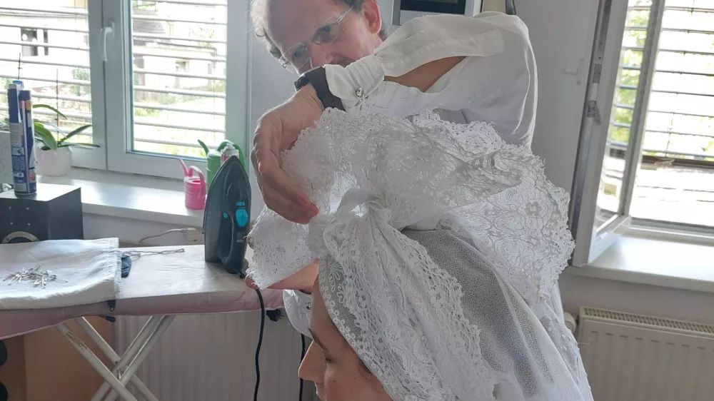 Pri pravilnem zavezovanju peče na glavi Barbari Didovič na pomoč priskoči Bojan Knific. Foto: Osebni arhiv