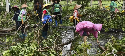 In this photo released by Xinhua News Agency, workers remove fallen tree branches along a street in the aftermath of Typhoon Yagi in Haikou, south China's Hainan Province, Saturday, Sept. 7, 2024. (Yang Guanyu/Xinhua via AP)