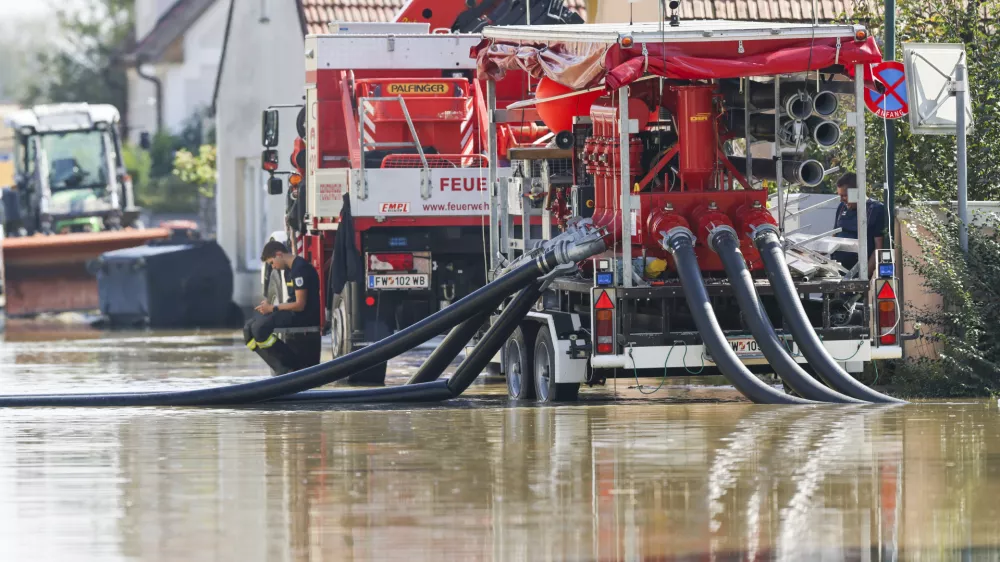 18 September 2024, Austria, Erpersdorf: In Kleinschoenbichl, the flood waters are still in many parts of the village and the fire department is using pumps to remove water from roads and fields. In Austria, the flood waters are receding slightly, but the situation remains tense and there is still a threat of dam failures and landslides. Photo: Christoph Reichwein/dpa