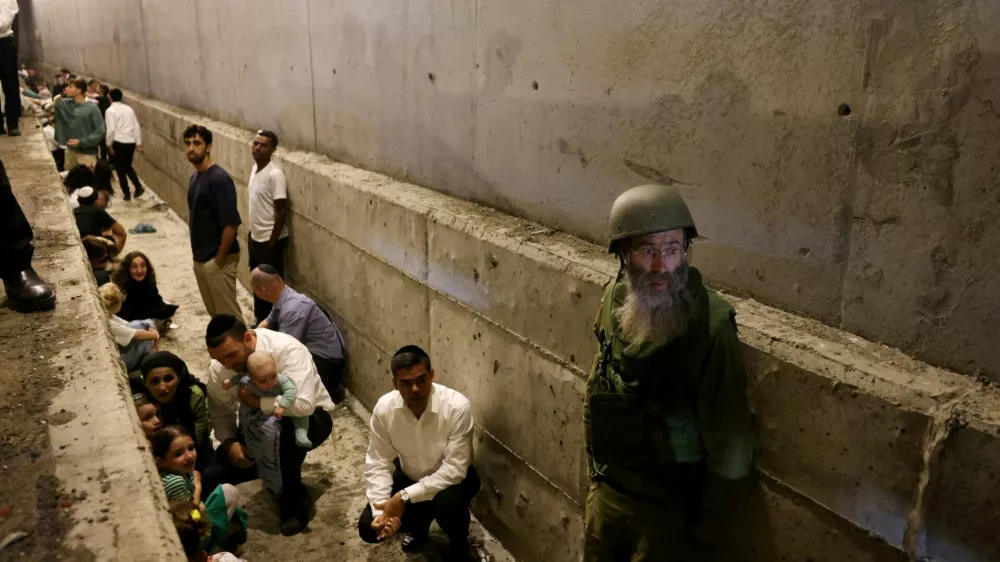 People take shelter during an air raid siren after Iran fired a salvo of ballistic missiles, amid cross-border hostilities between Hezbollah and Israel, in central Israel October 1, 2024. REUTERS/Ronen Zvulun ATTENTION EDITORS: ADDING INFORMATION   TPX IMAGES OF THE DAY