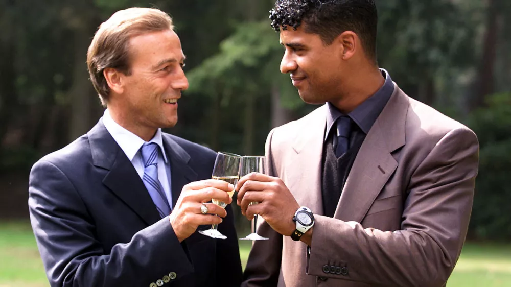 FILE PHOTO: Former Dutch soccer international Frank Rijkaard (R) toasts his new assistant Johan Neeskens at the Dutch soccer association's headquarters in Zeist August 31./File Photo