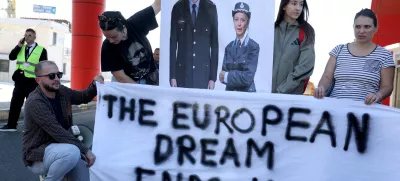 Activists holds a poster depicting Albanian Prime Minister Edi Rama and Italian Prime Minister Giorgia Meloni during a protest on the day migrants arrive on Italian navy ship Libra in Albania as part of a deal with Italy to process thousands of asylum-seekers caught near Italian waters, in Shengjin, Albania, October 16, 2024. REUTERS/Florion Goga
