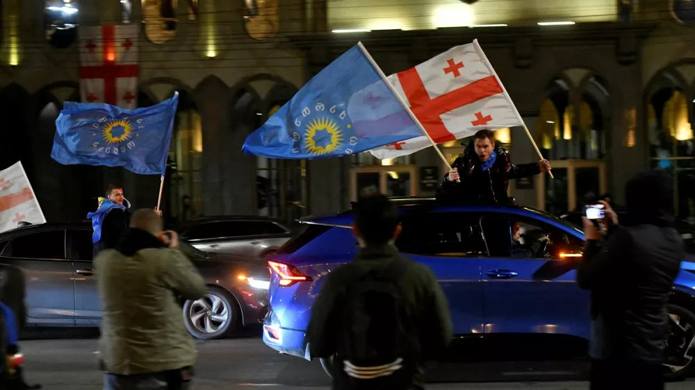 FILE PHOTO: Supporters of the Georgian Dream party wave Georgian flags and the party's flags from cars after the announcement of exit poll results in parliamentary elections, in Tbilisi, Georgia October 26, 2024. REUTERS/Zurab Javakhadze/File Photo