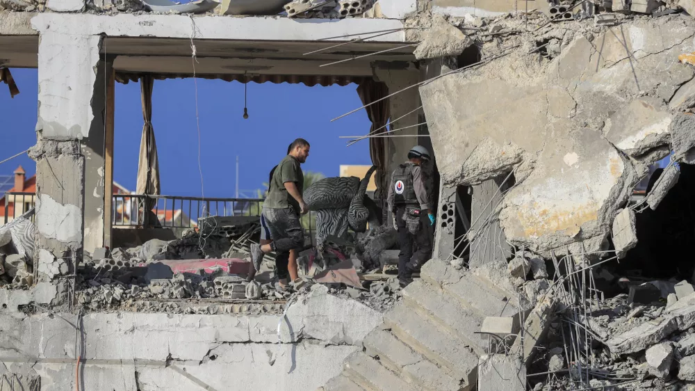 Rescue workers search for victims at a destroyed building hit in an Israeli airstrike, in Ghaziyeh town, south Lebanon, Sunday, Nov. 3, 2024. (AP Photo/Mohammed Zaatari)