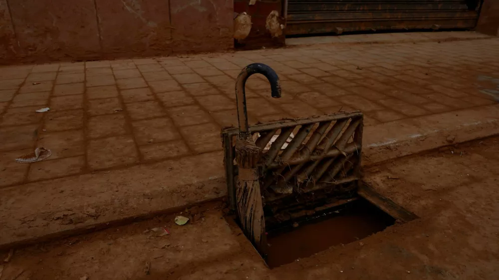 An umbrella is used to keep a storm drain grate blocked by mud open following catastrophic flooding, as Spain braces for torrential rain, in Paiporta, Valencia, November 13, 2024. REUTERS/Vincent West