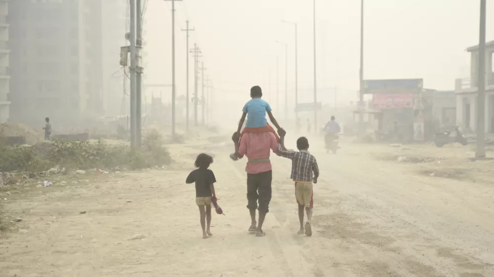 ﻿A village man walks carrying a child on his shoulders on a foggy day in Greater Noida, near New Delhi, India, Monday, Nov.5, 2018. With air quality reduced to "very severe" in the Indian capital region, authorities are bracing for a major Hindu festival featuring massive fireworks that threatens to cloak New Delhi with more toxic smog and dust. (AP Photo/R S Iyer)