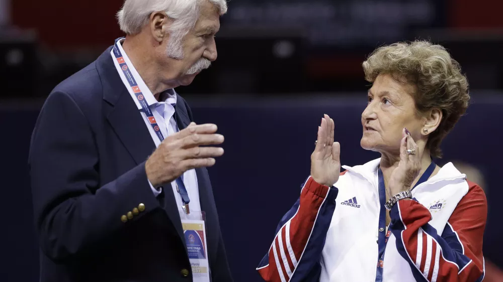 FILE - Bela Karolyi, left, and his wife, Martha Karolyi, talk on the arena floor before the start of the preliminary round of the women's Olympic gymnastics trials in San Jose, Calif., June 29, 2012. (AP Photo/Gregory Bull, File)
