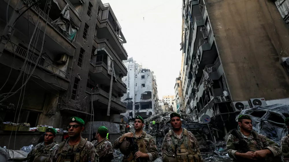 Civil defense members work as Lebanese army soldiers stand guard at the site of an Israeli strike in Beirut's Basta neighbourhood, amid the ongoing hostilities between Hezbollah and Israeli forces, Lebanon November 23, 2024. REUTERS/Thaier Al-Sudani