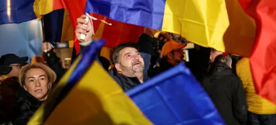 FILE PHOTO: A supporter of the radical right Alliance for Uniting Romanians (AUR) wave a Romanian flag, following the first exit polls, at the party's campaign headquarters, on the day of the parliamentary election, in Bucharest, Romania, December 1, 2024. REUTERS/Alkis Konstantinidis/File Photo